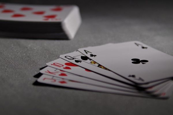 Free Detailed view of playing cards displaying a winning poker hand in a dimly lit scene. Stock Photo